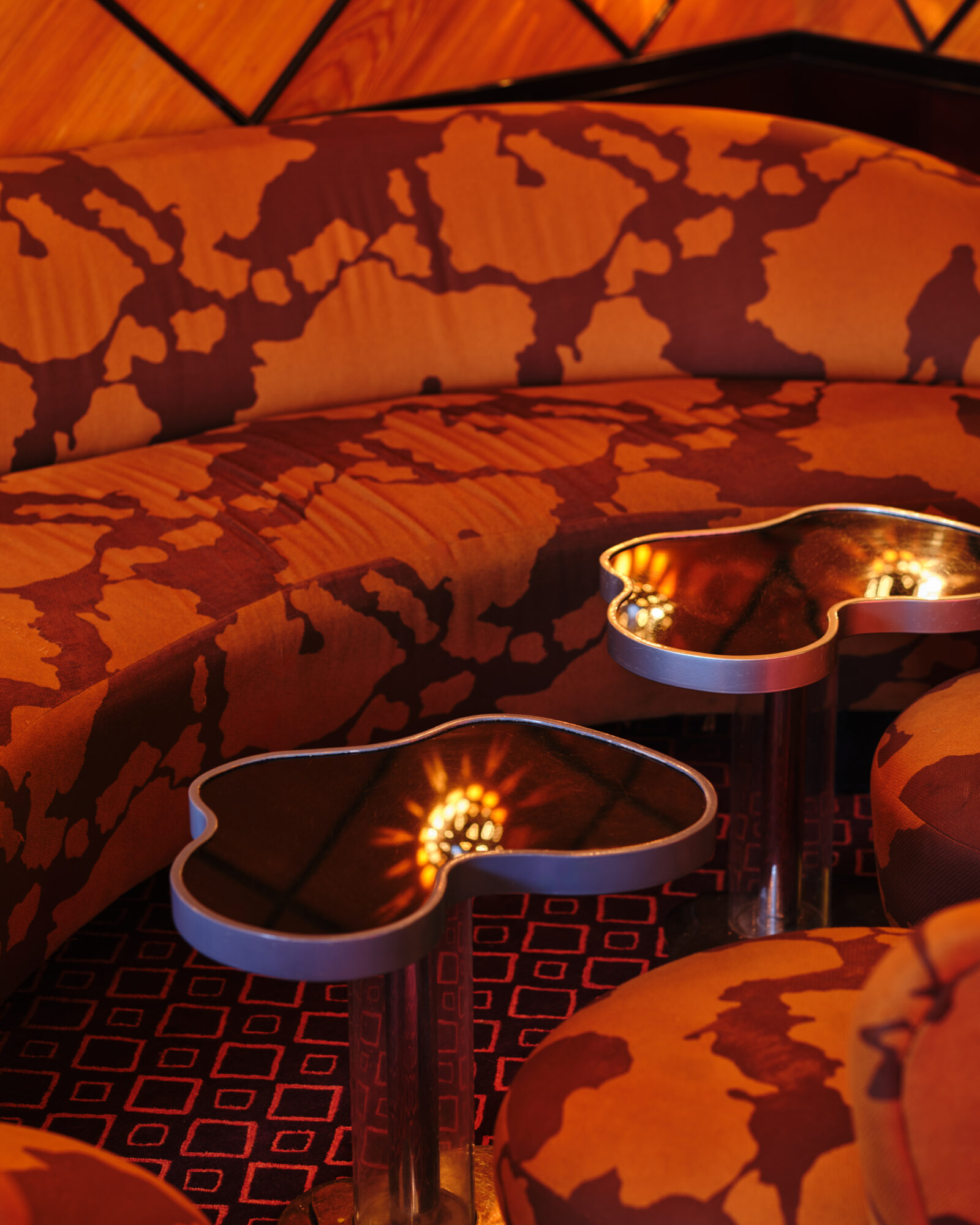 a dimly lit lounge with a sofa and tables